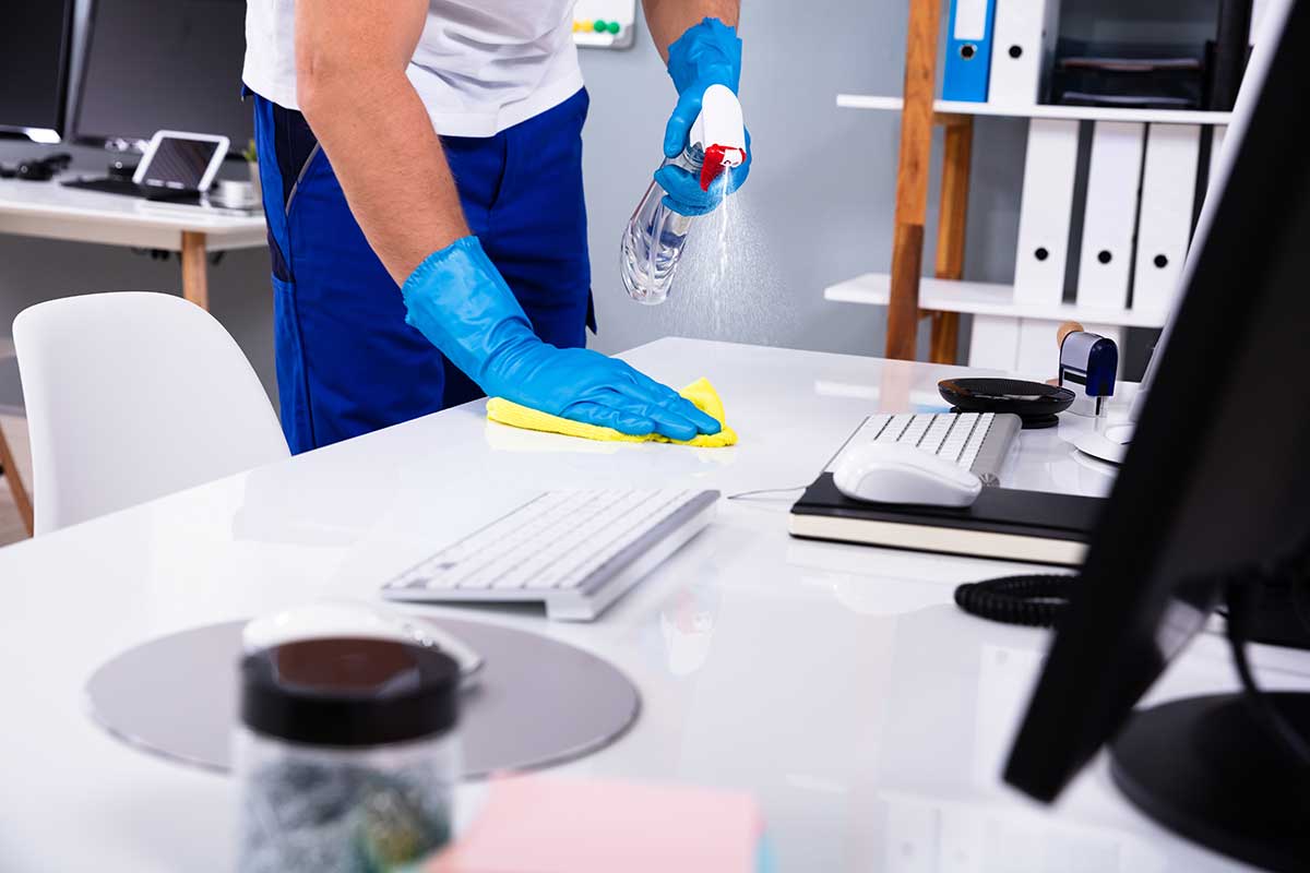 shutterstock_1401013190 Female janitor with vacuum cleaner in room